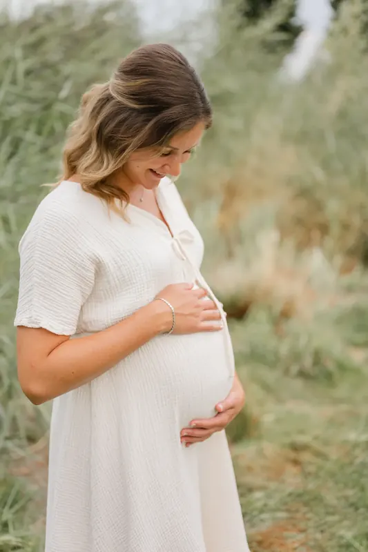 Babybauch mit Partner in natürlichem Licht
